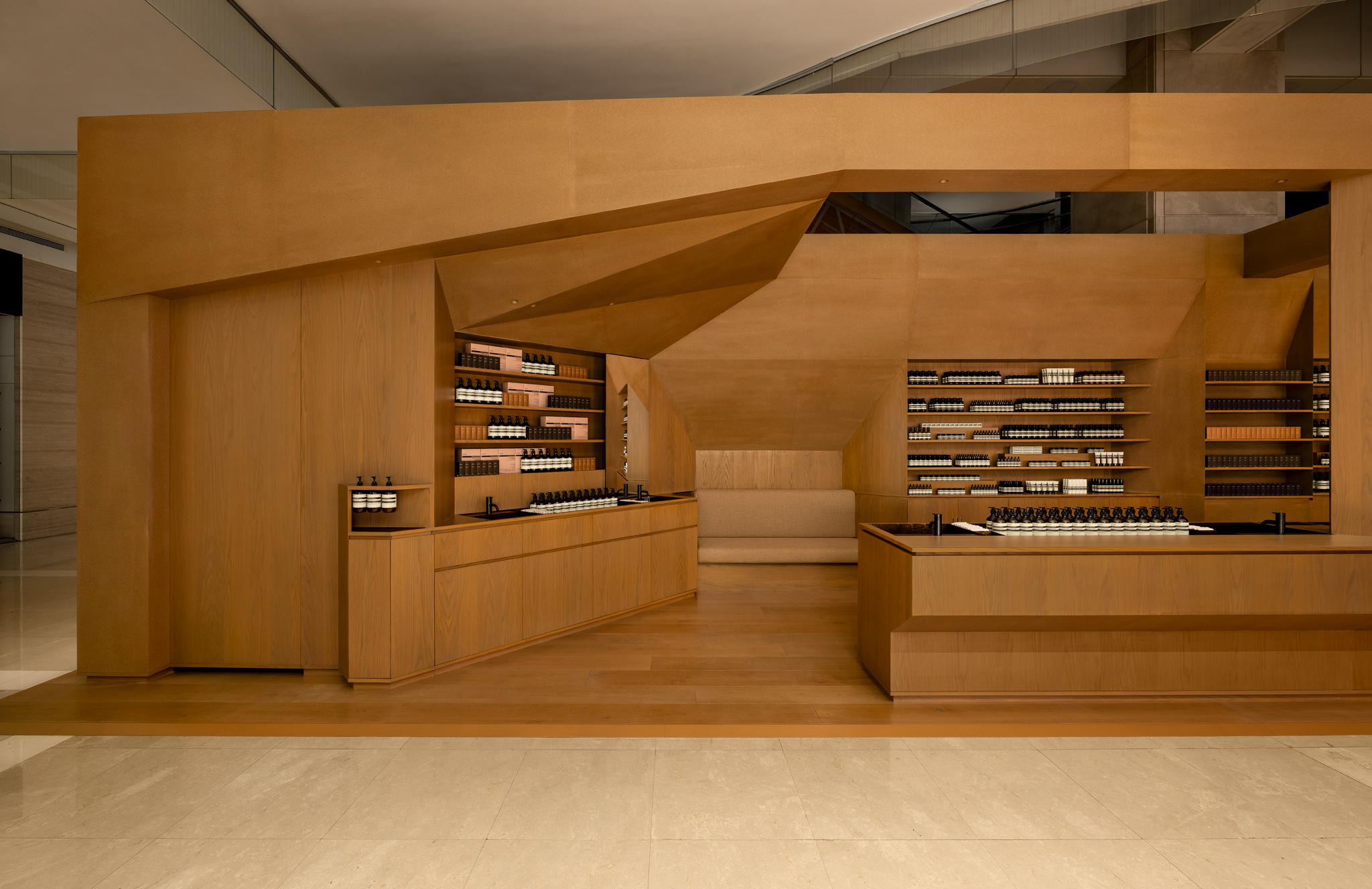 巨大的角形結構以大地色調包覆空間外殼，呈現內斂而均勻的視覺感受